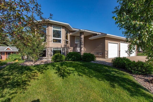 406 13th Ave NW, Kasson, MN 55944 - view of front facade featuring a garage, stone siding, a front yard, and concrete driveway