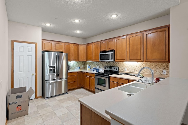 4543 Bloomberg Cir, Inver Grove Heights, MN 55076 - kitchen with stainless steel appliances, brown cabinetry, decorative backsplash, a textured ceiling, and light countertops