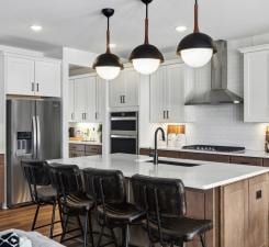 14560 106th Pl N, Maple Grove, MN 55369 - kitchen with stainless steel appliances, wall chimney exhaust hood, a breakfast bar area, pendant lighting, and recessed lighting