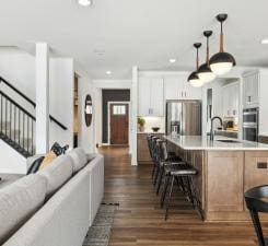 14560 106th Pl N, Maple Grove, MN 55369 - kitchen featuring appliances with stainless steel finishes, a kitchen breakfast bar, dark wood-style floors, light countertops, and recessed lighting