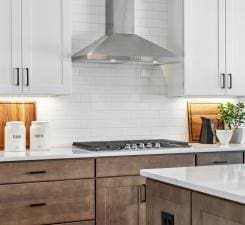 14560 106th Pl N, Maple Grove, MN 55369 - kitchen with wall chimney range hood, light countertops, tasteful backsplash, and gas cooktop