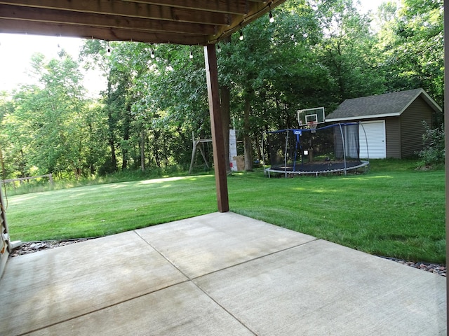 224 Country Ln, Durand, WI 54736 - view of grassy yard featuring a trampoline, a patio area, and a storage unit