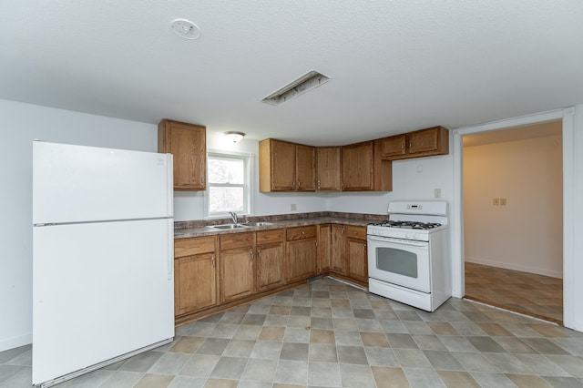 4163 Horseshoe Ct NE, Haverhill Twp, MN 55906 - kitchen with white appliances, brown cabinetry, dark countertops, and a textured ceiling