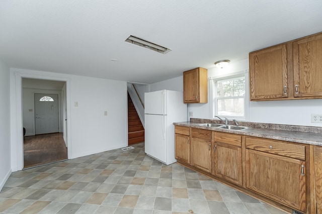 4163 Horseshoe Ct NE, Haverhill Twp, MN 55906 - kitchen featuring freestanding refrigerator and brown cabinetry