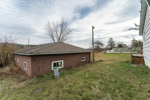 4163 Horseshoe Ct NE, Haverhill Twp, MN 55906 - view of side of property featuring concrete block siding, a lawn, roof with shingles, and a deck