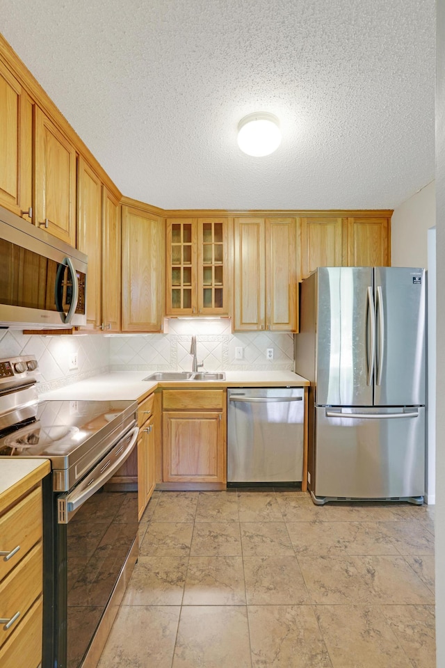 5643 Green Circle Dr Unit 107, Minnetonka, MN 55343 - kitchen with stainless steel appliances, backsplash, light countertops, glass insert cabinets, and a textured ceiling