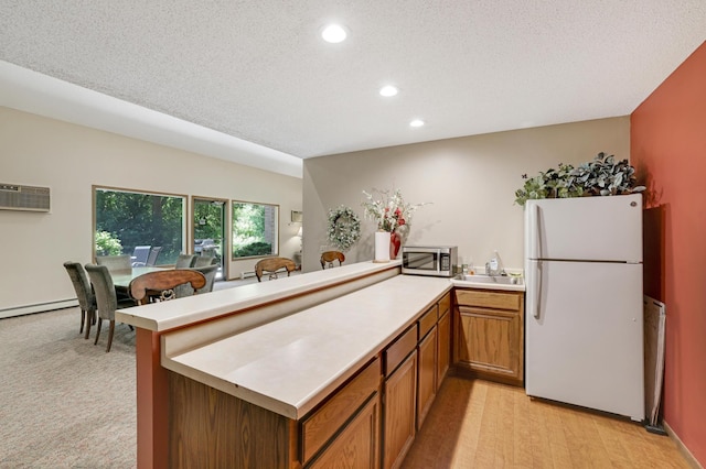 5643 Green Circle Dr Unit 107, Minnetonka, MN 55343 - kitchen with freestanding refrigerator, a peninsula, recessed lighting, light countertops, and brown cabinets