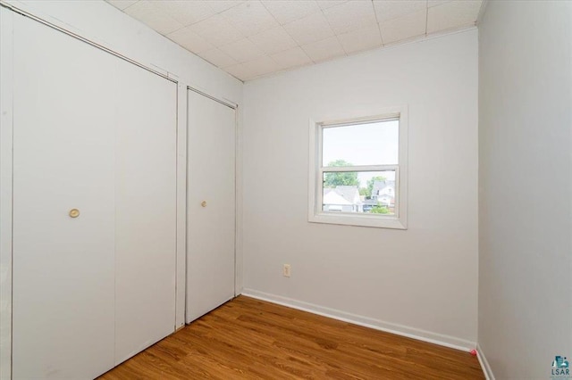 2014 5th St, Superior, WI 54880 - unfurnished bedroom with wood finished floors and two closets