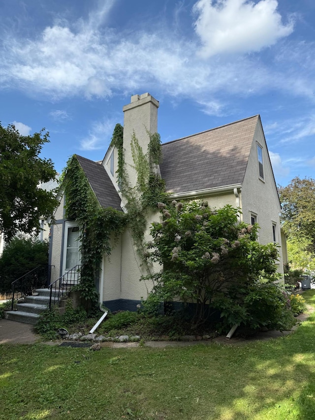 2639 Arthur St NE, Minneapolis, MN 55418 - view of side of property with roof with shingles, a chimney, and stucco siding