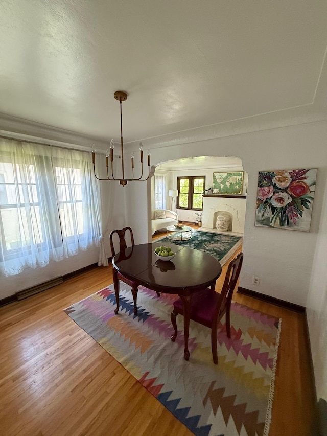 2639 Arthur St NE, Minneapolis, MN 55418 - dining area with a chandelier, wood finished floors, and arched walkways