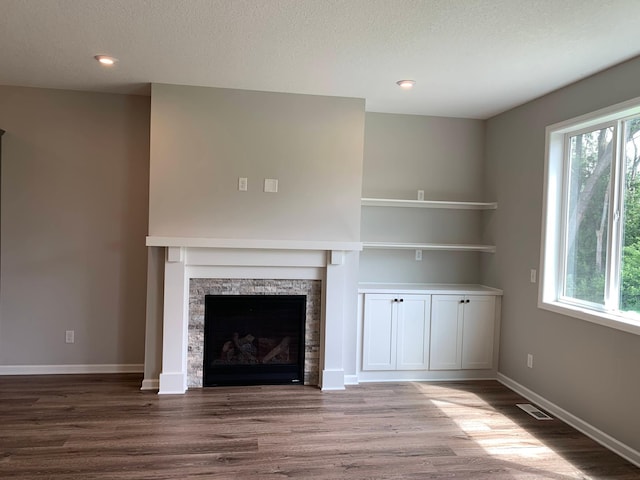 1248 100th Ave NW, Coon Rapids, MN 55433 - unfurnished living room featuring wood finished floors, plenty of natural light, a textured ceiling, and recessed lighting