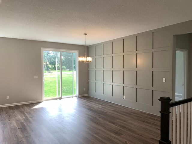 1248 100th Ave NW, Coon Rapids, MN 55433 - spare room featuring a chandelier, a decorative wall, a textured ceiling, and dark wood-style floors