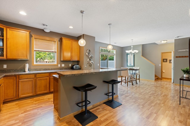9605 Scott Cir N, Brooklyn Park, MN 55443 - kitchen featuring light wood finished floors, brown cabinets, healthy amount of natural light, a textured ceiling, and recessed lighting