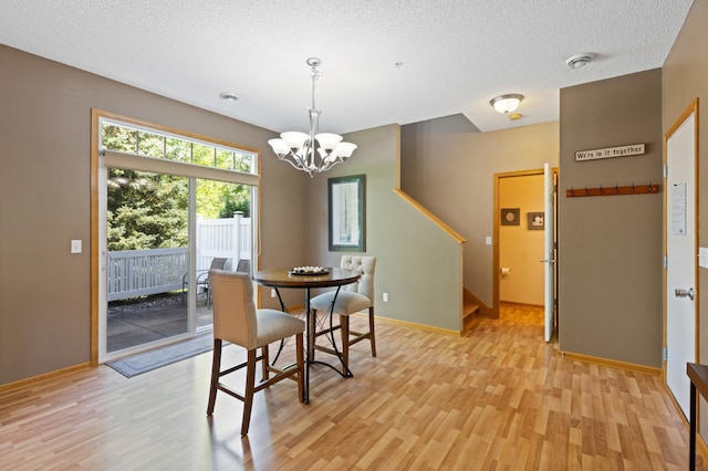 9605 Scott Cir N, Brooklyn Park, MN 55443 - dining room with light wood-type flooring, a chandelier, a textured ceiling, and stairs