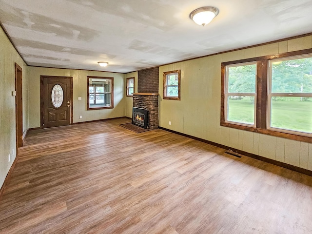 30867 Rasmussen Rd, Pequot Lakes, MN 56472 - unfurnished living room featuring wood finished floors and a brick fireplace