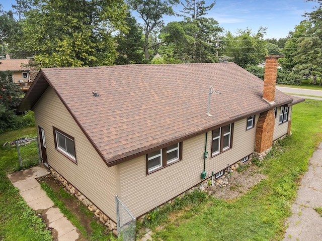 30867 Rasmussen Rd, Pequot Lakes, MN 56472 - view of side of property featuring a chimney, a shingled roof, and view of wooded area