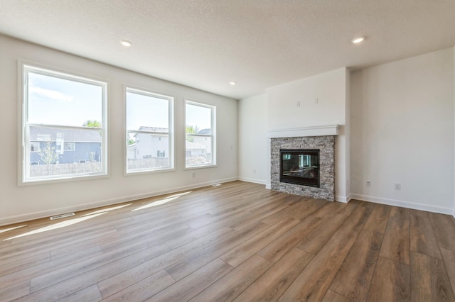 2550 Downing Ave, Shakopee, MN 55379 - unfurnished living room featuring wood finished floors, a fireplace, recessed lighting, and a textured ceiling
