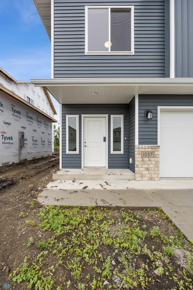 1057 61st Ave W, West Fargo, ND 58078 - doorway to property featuring covered porch and a garage