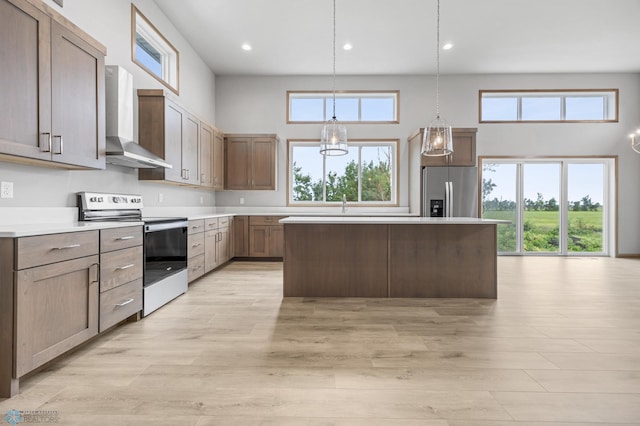 1057 61st Ave W, West Fargo, ND 58078 - kitchen with stainless steel appliances, wall chimney exhaust hood, a towering ceiling, a center island, and recessed lighting