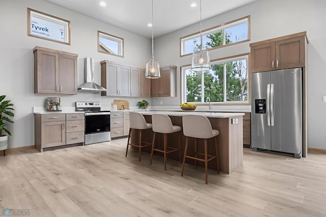1057 61st Ave W, West Fargo, ND 58078 - kitchen featuring appliances with stainless steel finishes, wall chimney exhaust hood, a towering ceiling, light countertops, and a kitchen breakfast bar