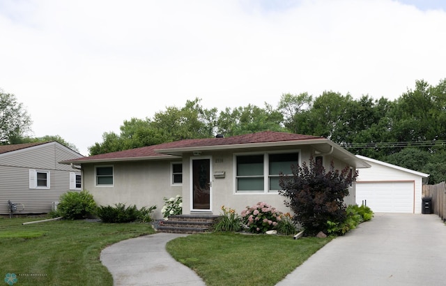 2510 10th St N, Fargo, ND 58102 - ranch-style home with stucco siding, a front yard, and a detached garage