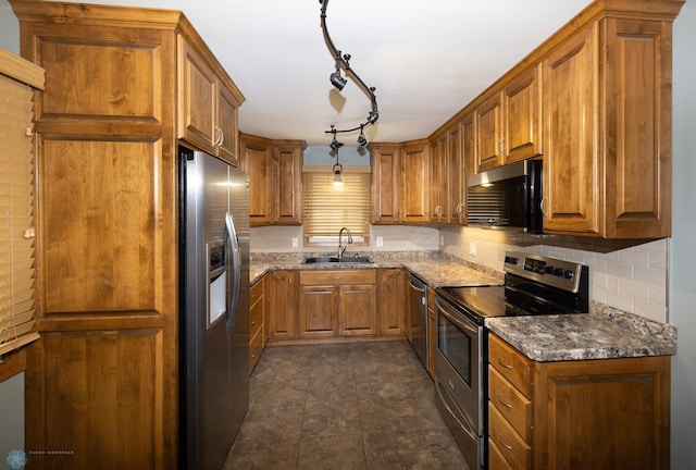 2510 10th St N, Fargo, ND 58102 - kitchen featuring stainless steel appliances, brown cabinets, dark stone counters, and tasteful backsplash