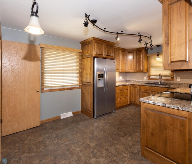 2510 10th St N, Fargo, ND 58102 - kitchen featuring stainless steel fridge, brown cabinets, pendant lighting, light stone counters, and black electric cooktop