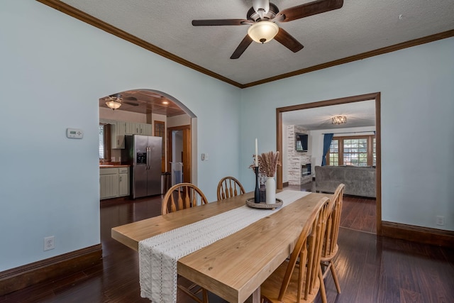 433 S Ave, North Mankato, MN 56003 - dining room featuring a ceiling fan, arched walkways, dark wood-type flooring, a textured ceiling, and ornamental molding