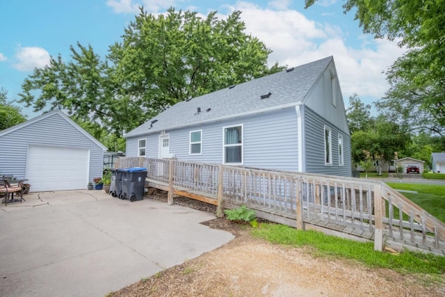 1109 Adams St, Mankato, MN 56001 - back of house with a garage, a shingled roof, an outdoor structure, concrete driveway, and a deck