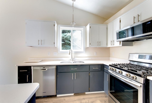 775 Leon St, Jordan, MN 55352 - kitchen featuring stainless steel appliances, vaulted ceiling, light countertops, light wood-style floors, and white cabinets
