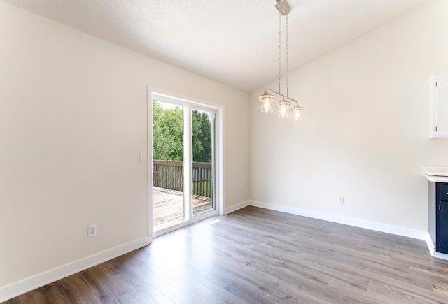 775 Leon St, Jordan, MN 55352 - unfurnished dining area with wood finished floors, lofted ceiling, and a chandelier