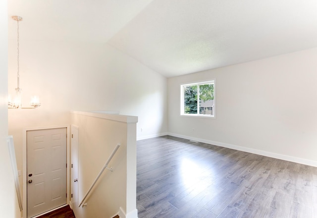 775 Leon St, Jordan, MN 55352 - unfurnished room featuring dark wood-type flooring, a chandelier, and lofted ceiling