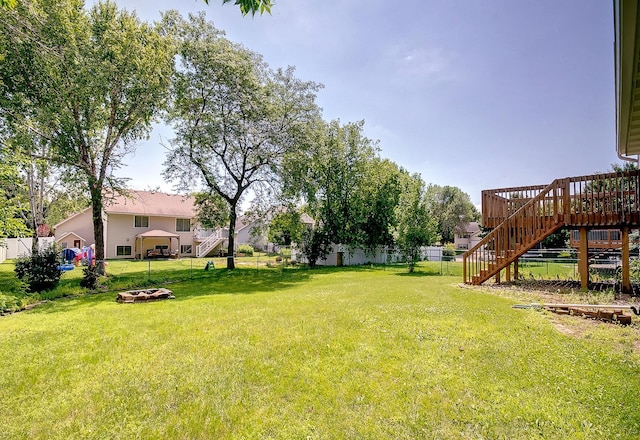 775 Leon St, Jordan, MN 55352 - fenced backyard featuring stairs, a wooden deck, and an outdoor fire pit