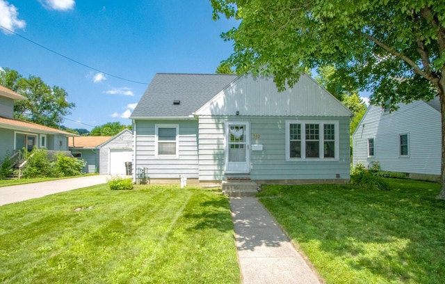 624 Garfield Ave, North Mankato, MN 56003 - bungalow featuring a front lawn, an outbuilding, roof with shingles, and a detached garage