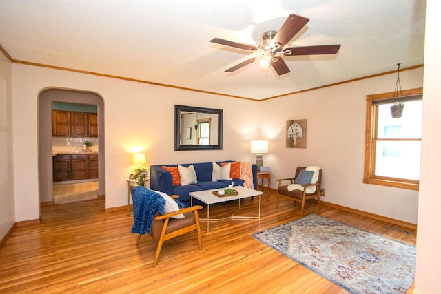 624 Garfield Ave, North Mankato, MN 56003 - living room with arched walkways, light wood-style floors, ornamental molding, and a ceiling fan