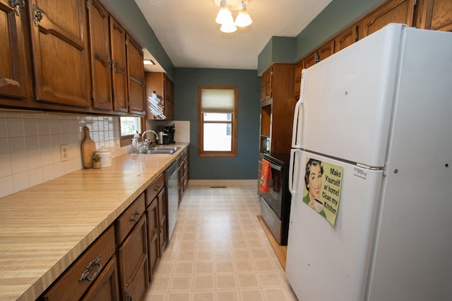 624 Garfield Ave, North Mankato, MN 56003 - kitchen with appliances with stainless steel finishes, light countertops, backsplash, light flooring, and brown cabinetry