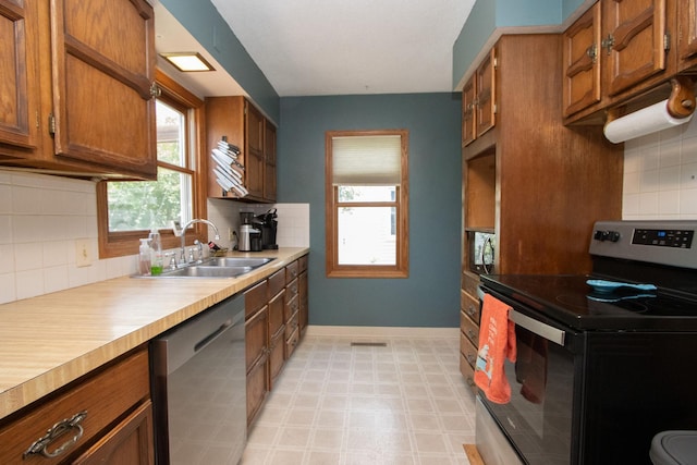 624 Garfield Ave, North Mankato, MN 56003 - kitchen featuring appliances with stainless steel finishes, brown cabinetry, backsplash, and light flooring