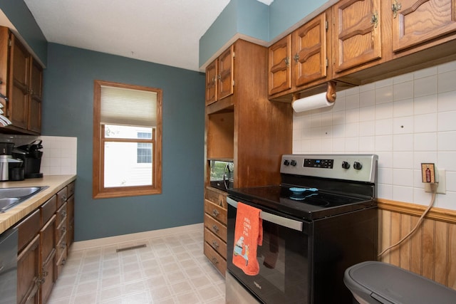624 Garfield Ave, North Mankato, MN 56003 - kitchen featuring stainless steel range with electric stovetop, backsplash, and brown cabinetry