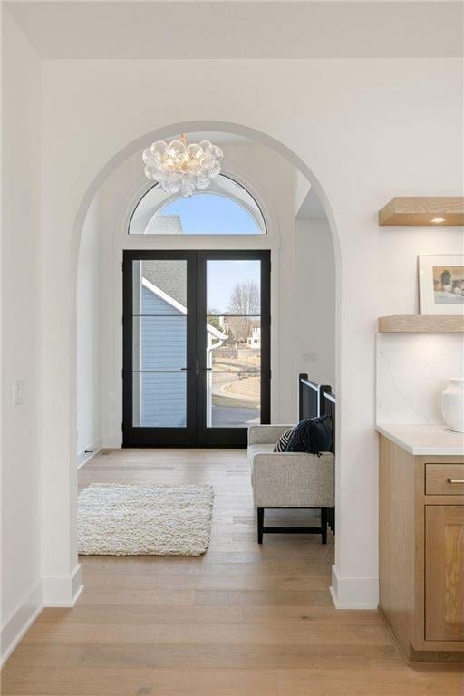 13975 27th St N, West Lakeland Twp, MN 55082 - entryway featuring arched walkways, light wood finished floors, french doors, and a chandelier