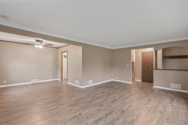 117 Division St, Mankato, MN 56001 - spare room featuring ceiling fan, wood finished floors, arched walkways, and a smoke detector