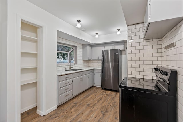 117 Division St, Mankato, MN 56001 - kitchen with freestanding refrigerator, electric range, tasteful backsplash, gray cabinetry, and wood finished floors