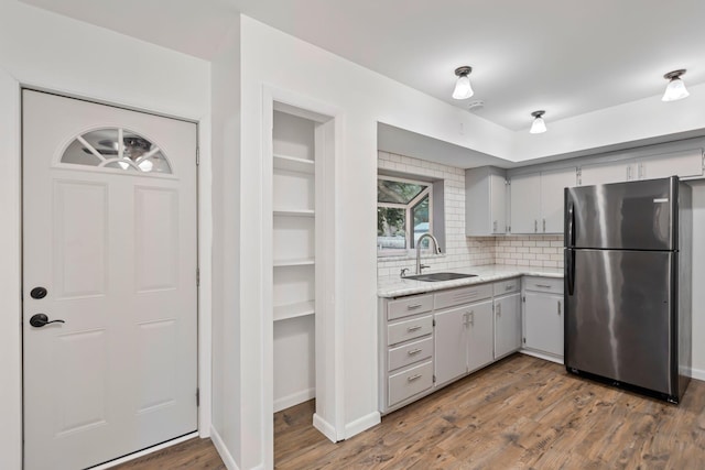 117 Division St, Mankato, MN 56001 - kitchen with freestanding refrigerator, wood finished floors, tasteful backsplash, and gray cabinetry