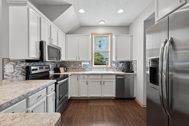 13433 Brick Path, Rosemount, MN 55068 - kitchen featuring appliances with stainless steel finishes, dark wood-style flooring, white cabinets, light countertops, and vaulted ceiling