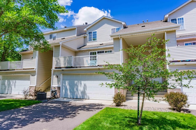 7639 Nicholas Way, Chanhassen, MN 55317 - back of house featuring concrete driveway, an attached garage, and a balcony