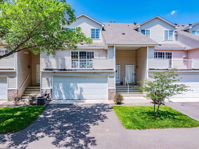 7639 Nicholas Way, Chanhassen, MN 55317 - view of front of house featuring asphalt driveway, an attached garage, a balcony, and a shingled roof