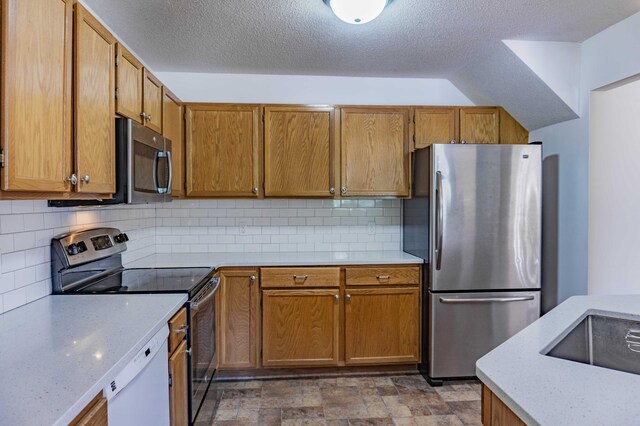 7639 Nicholas Way, Chanhassen, MN 55317 - kitchen featuring appliances with stainless steel finishes, backsplash, brown cabinets, a textured ceiling, and stone finish flooring