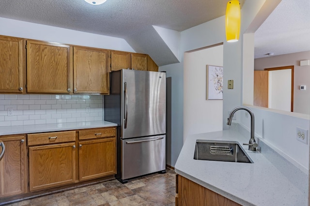 7639 Nicholas Way, Chanhassen, MN 55317 - kitchen featuring freestanding refrigerator, decorative backsplash, brown cabinets, a textured ceiling, and light stone countertops
