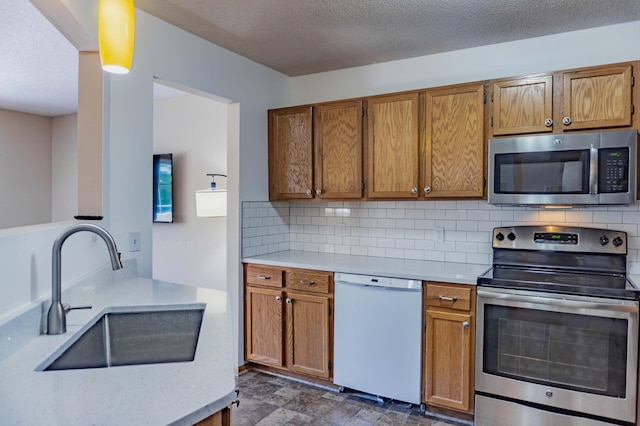 7639 Nicholas Way, Chanhassen, MN 55317 - kitchen with appliances with stainless steel finishes, brown cabinetry, decorative backsplash, and a textured ceiling