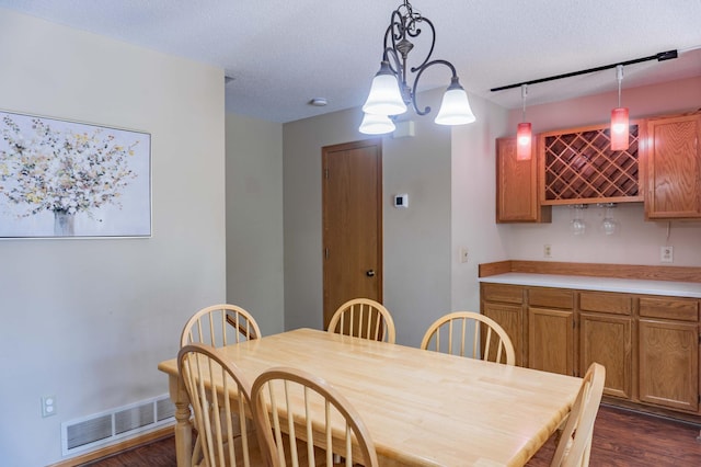 7639 Nicholas Way, Chanhassen, MN 55317 - dining room with a bar, dark wood-style flooring, and a textured ceiling
