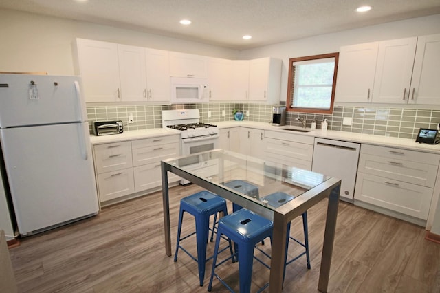 11715 Sorenson Lake Rd, Merrifield, MN 56465 - kitchen featuring white appliances, wood finished floors, white cabinetry, decorative backsplash, and recessed lighting
